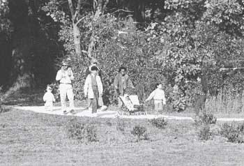 photo showing a family walking through natural landscaping in greenways