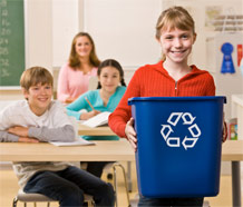 girl in classroom holding recycling bin