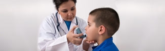 child being shown how to use an inhaler
