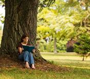 Girl reading book under a tree