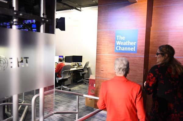 Administrator McCarthy walking past a Weather Channel sign.