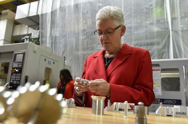 Administrator McCarthy at a lab table surrounded by various parts.