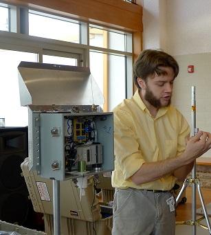 Photo of a researcher demonstrating an air monitor to the Ironbound Community