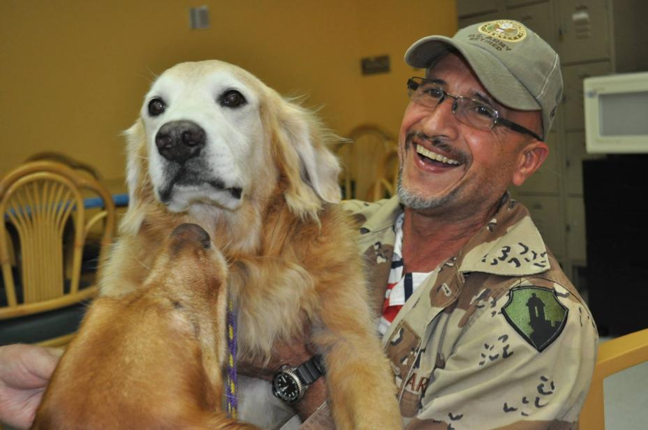 Foto de veterano sonriendo con un perro en las manos