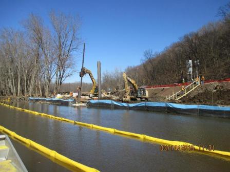 Workers install sheet pile along the Galena River to protect the area from rising water levels.