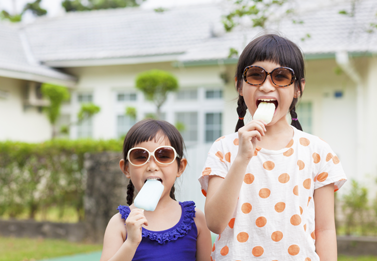 Girls eating Popsicles outside