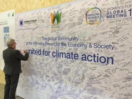 Gina McCarthy signing a wall at COP 21