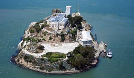 Aerial view of Alcatraz with solar panels on roof of main building clearyl visible, covering entire roof.