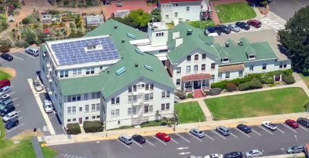 Aerial view of Alcatraz with solar panels on roof of main building clearyl visible, covering entire roof.