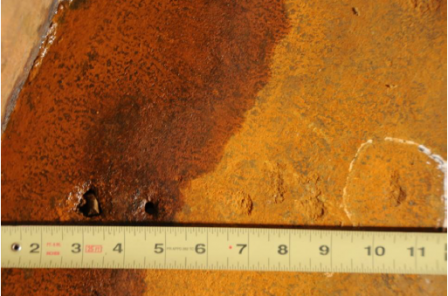 evidence photo showing holes in tank with ruler