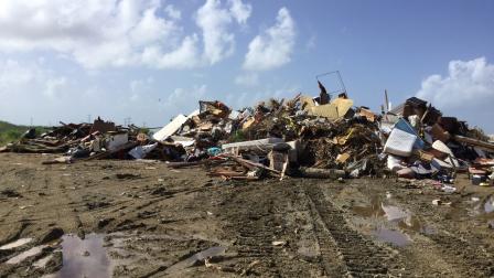 Debris piles requiring segregation of recyclable, vegetative and hazardous materials in Guayama, Puerto Rico
