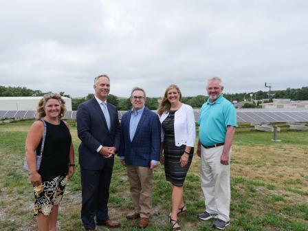 Acting Administrator Wheeler stands in a field in front of solar panels with two other men and two women