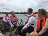Acting Administrator Wheeler sits looking on as New Bedford Mayor John Mitchell speaks on a boat at the New Bedford Superfund Site