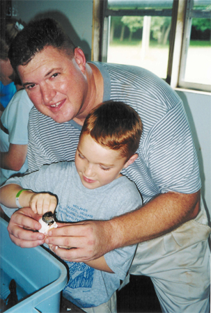 Barry and son Nicholas hatch a baby alligator at InstaGator Ranch and Hatcheries.