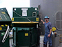 Offshore worker begins the recycling process by separating recyclables of tin, aluminum, cardboard, paper, plastic and compacting them into green bags at the source.