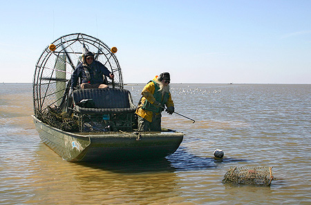 Government Category - 2nd Place: A volunteer working with a Texas Parks and Wildlife enforcement agent to remove derelict crab traps in Trinity Bay, Texas.