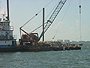 A barge carrying reef balls uses a crane to deploy reef balls at the