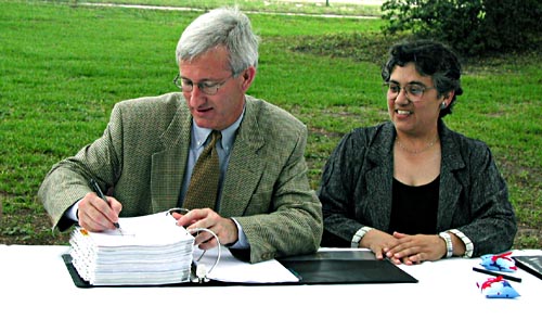 Photo 1:Left to Right: Ronnie Musgrove, Governor of the state of Mississippi, signing CIAP plan; Jayne Buttross, Director of Coastal Impact Assistance Program (CIAP), Mississippi Department of Environmental Quality, looking on.