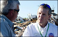 EPA Region 7 Administrator Karl Brooks coordinates with a representative from the Missouri Department of Natural Resources as they survey the tornado damage