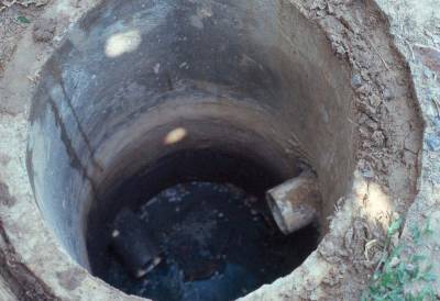 The photo shows a view of an open manhole looking down from above. 