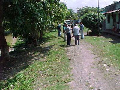 The photo shows the members of the environmental committee walking in a residential area located beside the river. 