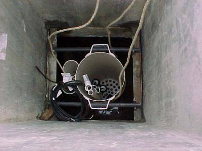 The photo shows the pump vault from above looking down into the concrete pumping tank. 