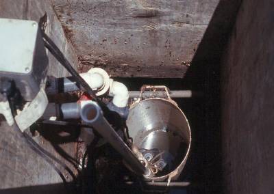 The photo shows the pump vault and electrical box from above looking down into the concrete pumping tank. 