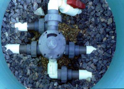 The photo shows a view from above of multiple pvc distribution lines coming together into the distribution valve. 