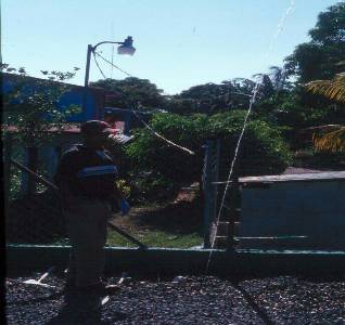 The photo shows a person standing next to a squirt of water coming from a distribution line on top of the sand filter.