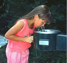 girl drinking from a water fountain
