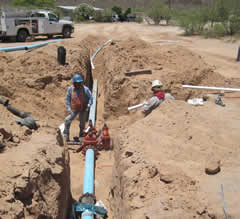 Workers James Johnson and Gary Wilson, Jr. install a valve to connect the Gunsight community wells to the upgraded water distribution system.