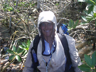 researcher wearing a suit that protects her from biting insects in the swamp