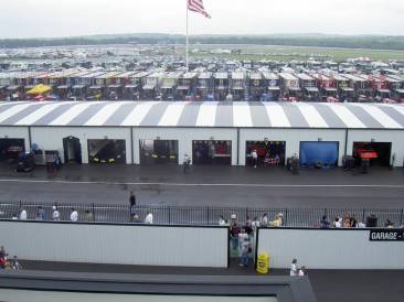 garage area with 18 wheel team transporters lined up behind garages