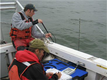 two men in boat sampling open water