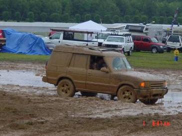 four-wheel drive covered in mud in the race infield