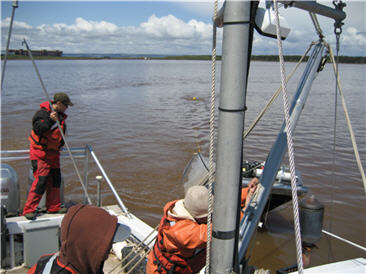 tucker trawl being lowered off the side of a boat in open water