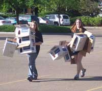 Women carrying cardboard boxes for recycling